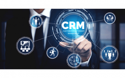 Un homme en costume interagissant avec un écran tactile affichant un cercle central avec le sigle "CRM" (Customer Relationship Management), connecté à d'autres icônes de gestion, vente et équipe. L'image symbolise la gestion centralisée de la relation client.