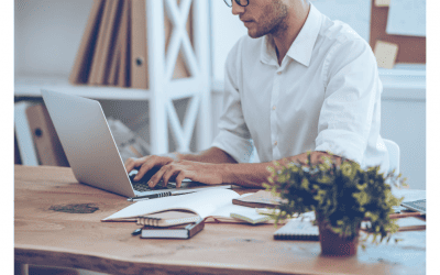 Un homme concentré tapant sur son ordinateur portable à un bureau, illustrant le travail quotidien d'un community manager. L'image évoque la gestion d'une présence en ligne.