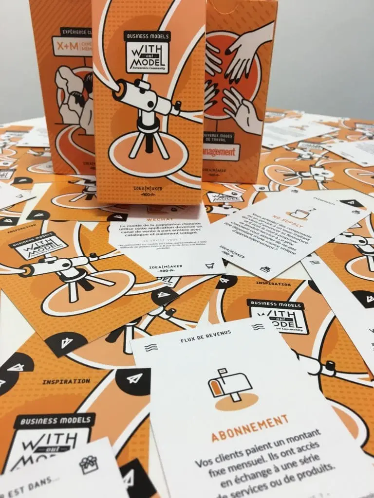 Des jeux de cartes et des boîtes d'atelier Idea Maker, avec des cartes sur les business models, l'expérience client et les nouveaux modes de travail, illustrant les outils de l'atelier de brainstorming.