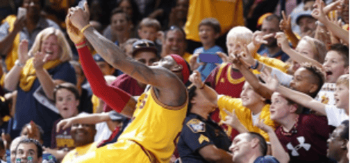 Un joueur de basket-ball en pleine action se penchant vers des fans excités, symbolisant l'engagement et l'interaction forte entre une marque et sa communauté. L'image est une métaphore du marketing interactif.