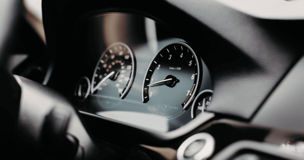 Vue détaillée du tableau de bord d'une voiture, montrant les compteurs de vitesse et de tours, symbolisant la mesure du kilométrage et l'optimisation des frais de déplacement d'entreprise - Digitandco.