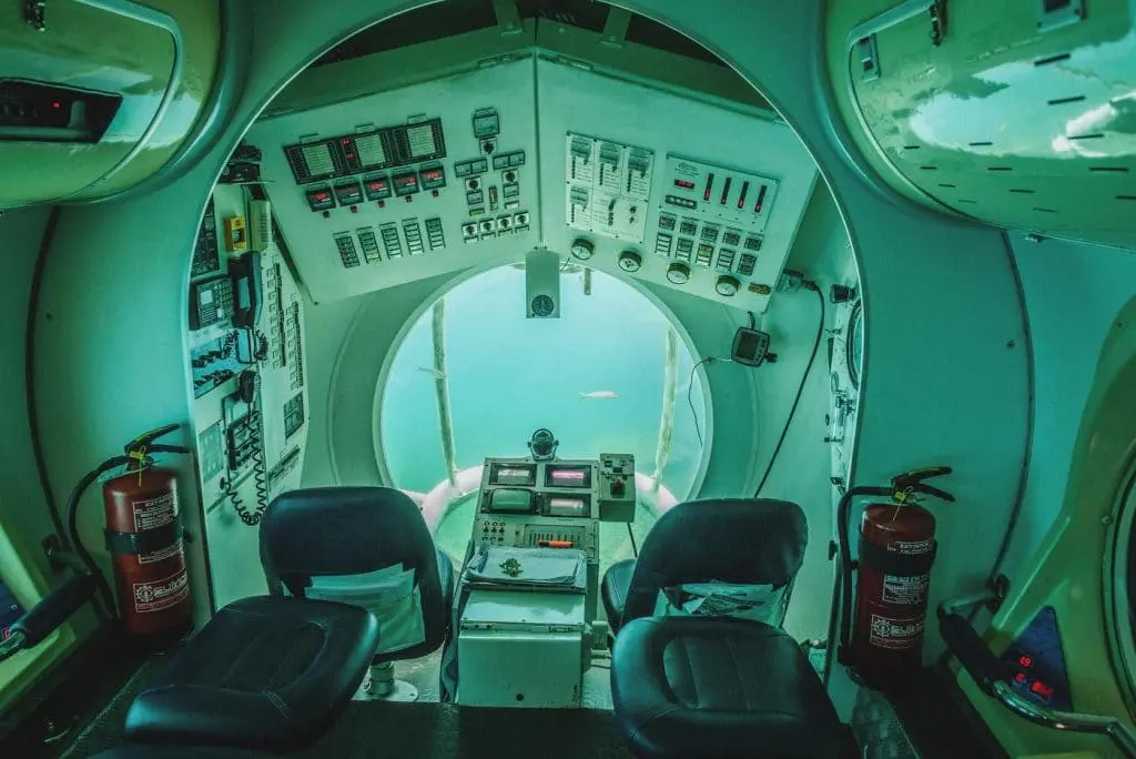 Le cockpit d'un sous-marin ou d'un submersible, rempli de tableaux de bord et de commandes, symbolisant la nécessité de fixer des indicateurs précis pour piloter et mesurer sa présence sur les réseaux sociaux.