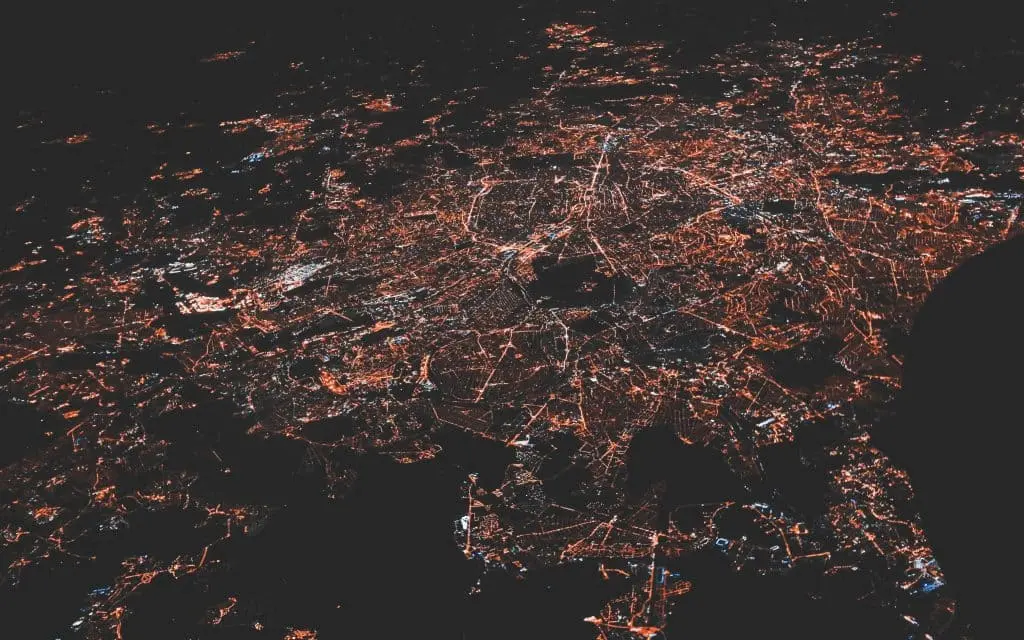 Vue aérienne d'une ville la nuit, dont les lumières forment un réseau dense et interconnecté, symbolisant un réseau professionnel de contacts sur les réseaux sociaux.