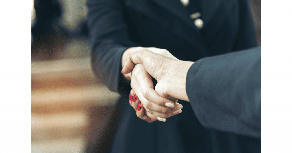Poignée de main entre deux personnes en costume, symbolisant la confiance et la relation client